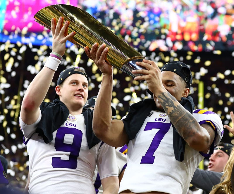 LSU Tigers safety Grant Delpit (7) hoists the national championship trophy with quarterback Joe Burrow (9) after a victory against the Clemson Tigers in the College Football Playoff national championship game at Mercedes-Benz Superdome.