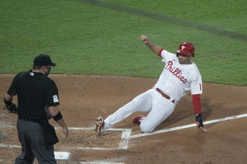 Philadelphia Phillies first baseman Neil Walker (12) slides safely into home plate on Philadelphia Phillies catcher Andrew Knapp (15) (not pictured) RBI single during the second inning against the New York Yankees at Citizens Bank Park.