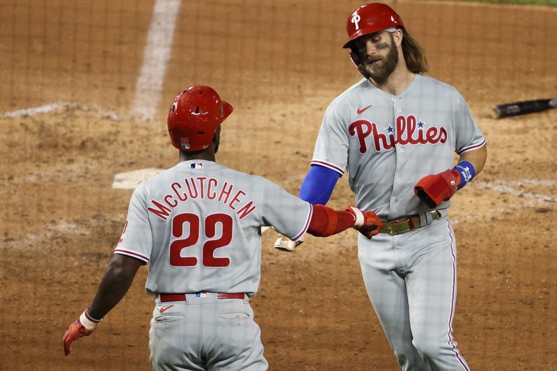 Philadelphia Phillies right fielder Bryce Harper (3) and Phillies center fielder Andrew McCutchen (22) celebrate after scoring runs against the Washington Nationals in the ninth inning at Nationals Park.