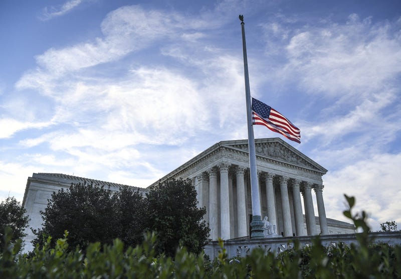The United States Supreme Court with American flag at half staff as people mourn outside of the United States Supreme Court on Saturday, September 19, 2020 after Court Justice Ruth Bader Ginsburg died on Friday, September 18, 2020.