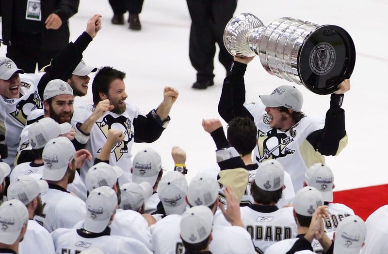Pittsburgh Penguins center Sidney Crosby (top right) celebrates with teammates after receiving the Stanley Cup following game seven of the 2009 Stanley Cup finals against the Detroit Red Wings a