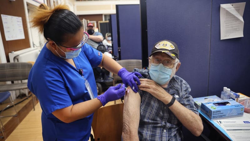 Lalain Reyeg administers a COVID-19 booster vaccine and an influenza vaccine to Army veteran William Craig at the Edward Hines Jr. VA Hospital on September 24, 2021 in Hines, Illinois. 
