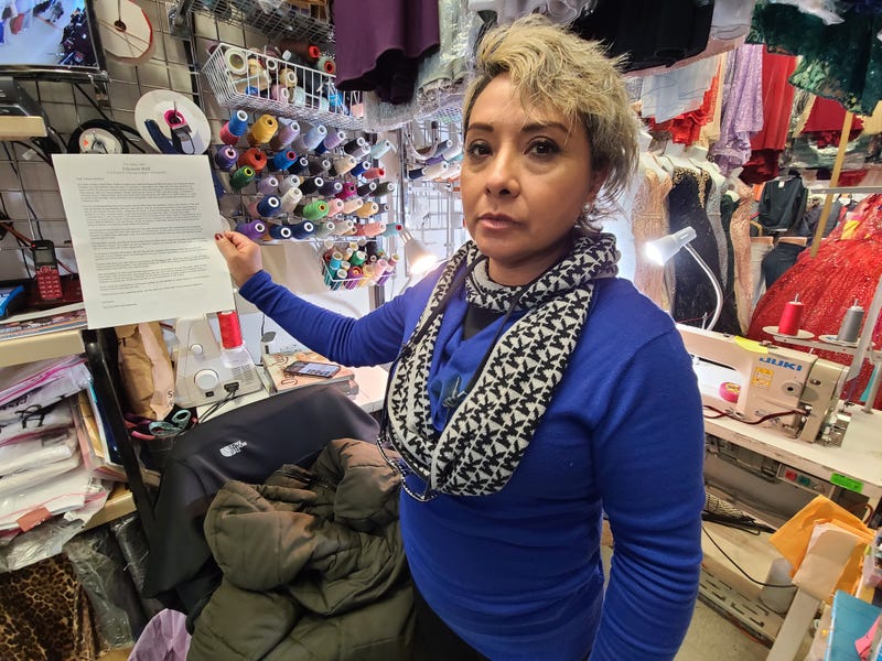 Little Village vendor holding up a letter