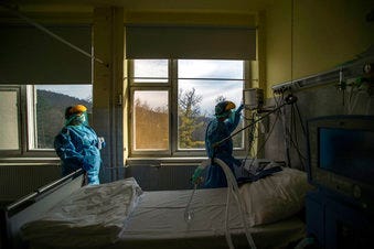 FILE - In this March 24 file photo, medical staff members check a ventilator in protective suits at the care unit for the new COVID-19 infected patients inside the Koranyi National Institute of Pulmonology in Budapest. (Zoltan Balogh/MTI via AP, File)