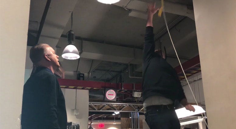 Gregg Giannotti (right) participates in a vertical jump competition in the WFAN newsroom.