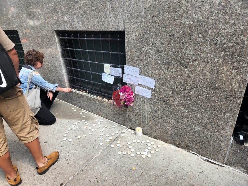 One of Hernandez's friends lights a candle on a shrine adorned with flowers and messages from mourners.