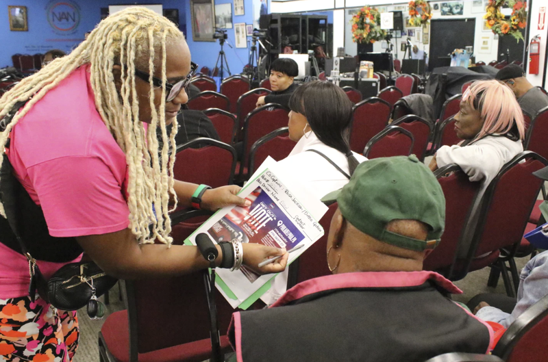 An organizer with the National Action Network signs people in ahead of a Get Out the Vote bus tour toward Philadelphia in the Harlem neighborhood of New York on Friday, Sept. 27, 2024.