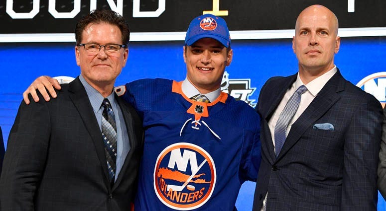 Islanders' first-round draft pick Oliver Wahlstrom poses with with team representatives after being selected as the 11th overall pick.