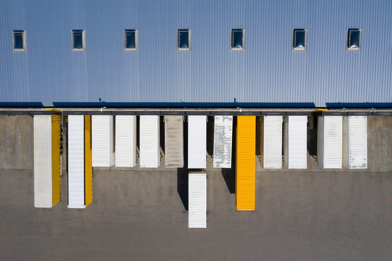 Aerial view of cargo containers, industrial warehouse, storage building and loading docks
