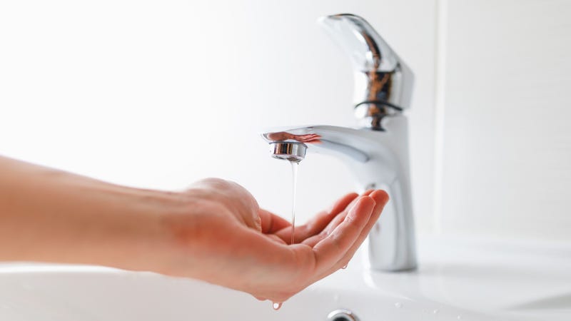 Hand under faucet - stock photo