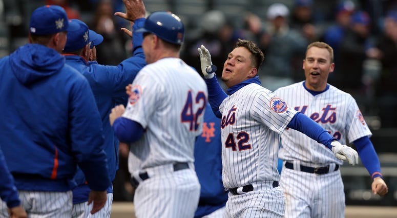 The Mets' Wilmer Flores celebrates with teammates after hitting a walk-off solo home run to beat the Milwaukee Brewers on April 15, 2018, at Citi Field.