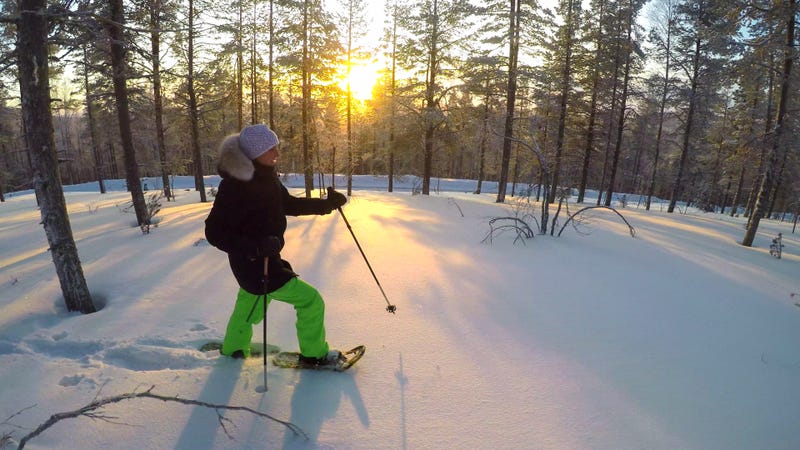 Woman on snowshoes with the sun behind her