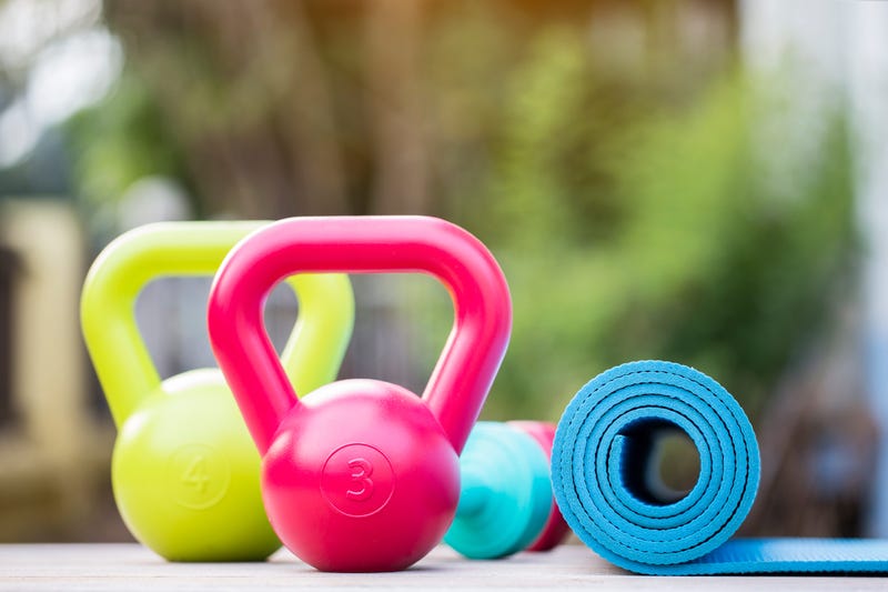 Kettlebell, dumbbell and yoga mat on wood table