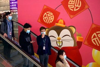 People wear face masks as they ride an escalator at the Hong Kong International Airport in Hong Kong, Tuesday, Jan. 21, 2020.(AP Photo/Ng Han Guan)