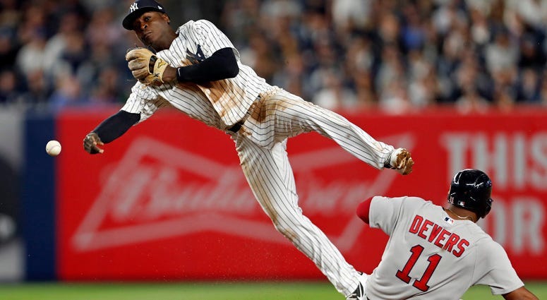 Yankees shortstop Didi Gregorius (18) turns the double play as the Red Sox's Rafael Devers slides into second base during the fourth inning at Yankee Stadium on May 9, 2018.