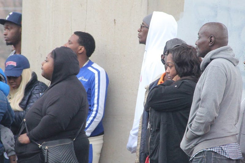 Rapper Young Thug (white hoodie) is among a group of onlookers at the scene of a deadly double shooting