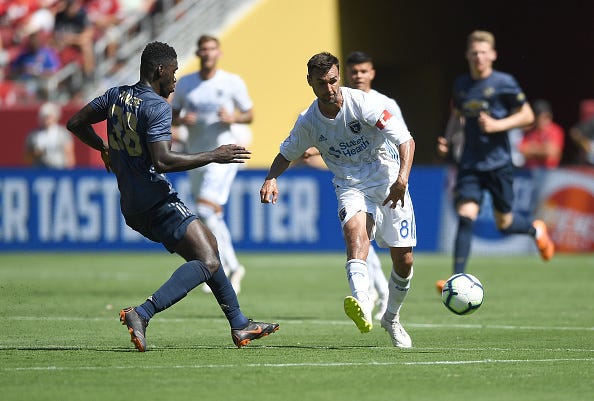 Chris Wondolowski #8 of the San Jose Earthquakes dribbles the ball up the field while defended by Axel Tuanzebe #38 of Manchester United during the second half of their exhibition soccer game at Levi's Stadium on July 22, 2018 in Santa Clara, California. 