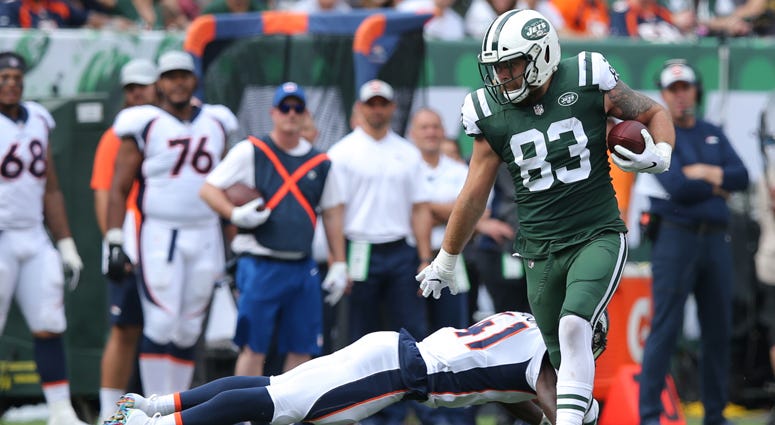 Jets tight end Eric Tomlinson carries the ball past Denver Broncos cornerback Isaac Yiadom on Oct. 7, 2018, at MetLife Stadium. 