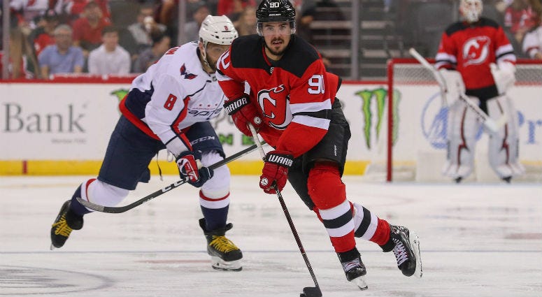 Marcus Johansson skates with the puck while being pursued by Alex Ovechkin during the second period at Prudential Center.