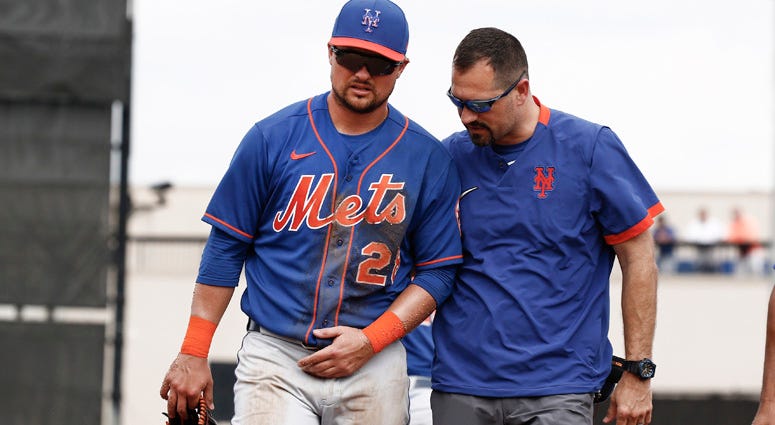 Mets third baseman J.D. Davis is assisted off the field by a trainer after hurting his shoulder against the Detroit Tigers on Feb. 25, 2020, at Joker Marchant Stadium in Lakeland, Florida.  