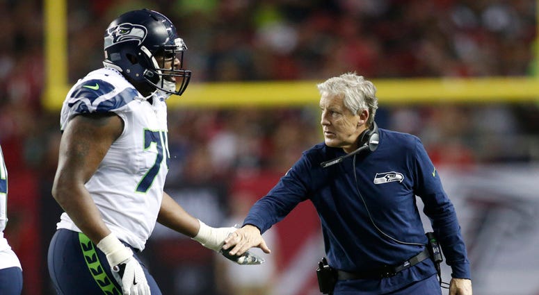 Seahawks coach Pete Carroll high-fives offensive tackle George Fant during the second quarter against the Falcons in the NFC Divisional playoff at the Georgia Dome in Atlanta on Jan. 14, 2017.    Seahawks coach Pete Carroll high-fives offensive tackle George Fant during the second quarter against the Falcons in the NFC Divisional playoff at the Georgia Dome in Atlanta on Jan. 14, 2017.