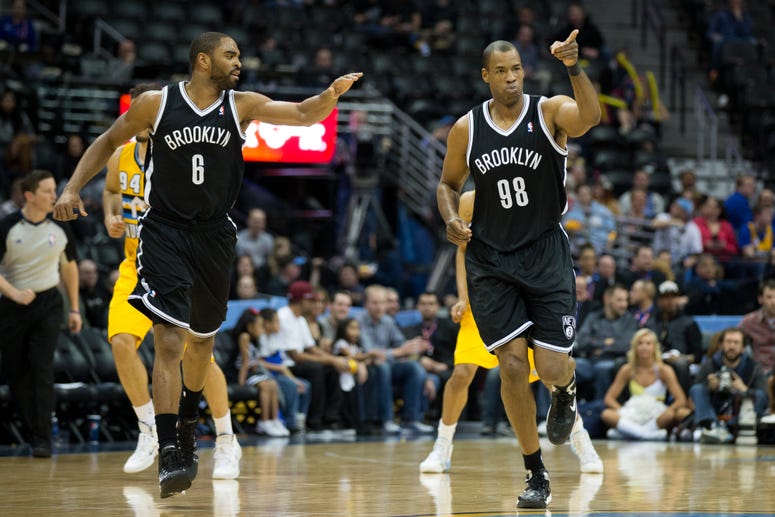 Jason Collins of the Nets celebrates after making a basket with teammate Alan Anderson #6 during a game against the Denver Nuggets at Pepsi Center on February 27, 2014 in Denver, Colorado.