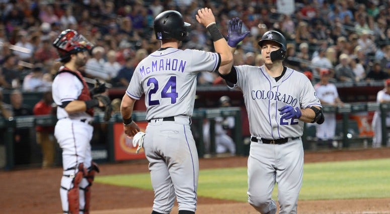 Colorado Rockies pinch hitter Chris Iannetta (22) slaps hands with Colorado Rockies second baseman Ryan McMahon (24) after hitting a two-run home run against the Arizona Diamondbacks during the eighth inning on Jul 7, 2019 at Chase Field.