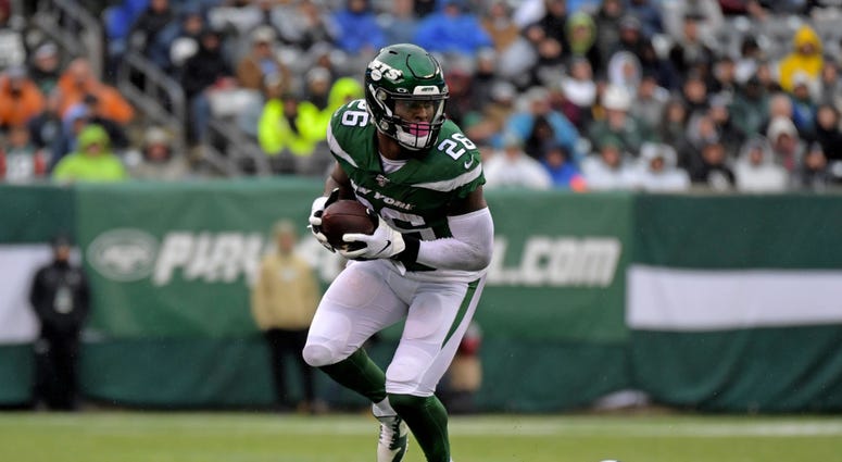 New York Jets running back Le'Veon Bell runs away from Oakland Raiders cornerback Trayvon Mullen Nov 24, 2019; East Rutherford, NJ
