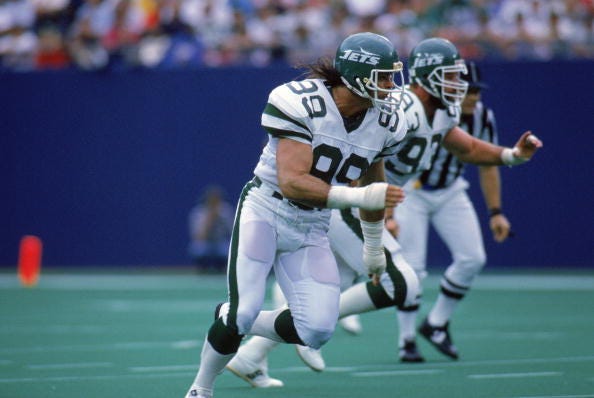 Jets DE Mark Gastineau charges forward on the field. 